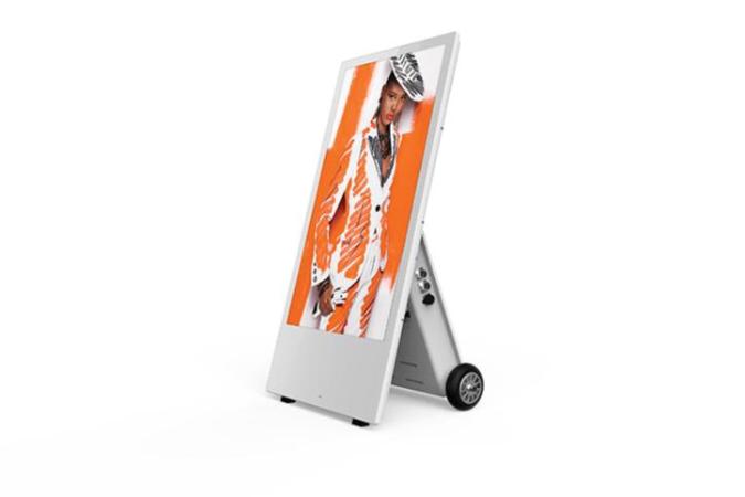 A portable digital display with a screen showing an image, white, 43'' outdoor or indoor