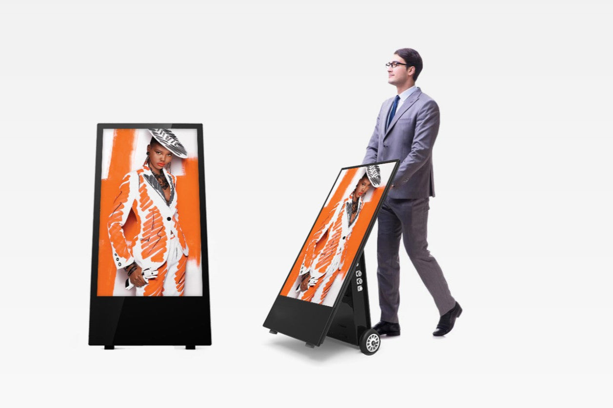 Man pushing a digital Outdoor A-Board display stand with a fashion-themed poster on a white background