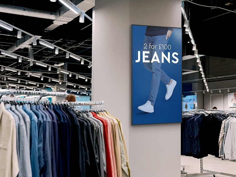 Clothing store interior with jeans display and promotional sign. Vibrant Professional Advertising Displays 800cd/m2 Brightness Commercial grade for bright spaces, as a menu, advertising, informing, 4K Resolution with android 14 Be Quantum